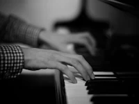 a black and white photo of a person playing a piano