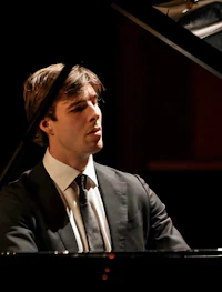 a man in a suit playing a piano